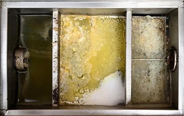 Stainless steel grease trap with baffles and separate compartments in a Los Angeles restaurant kitchen